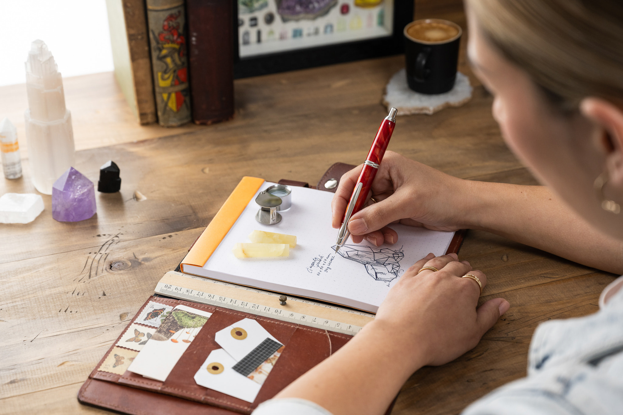 An artist labelling her sketch in a notebook in calligraphy using a Capless SE fountain pen, showcasing the versatility of fountain pens in creative work.