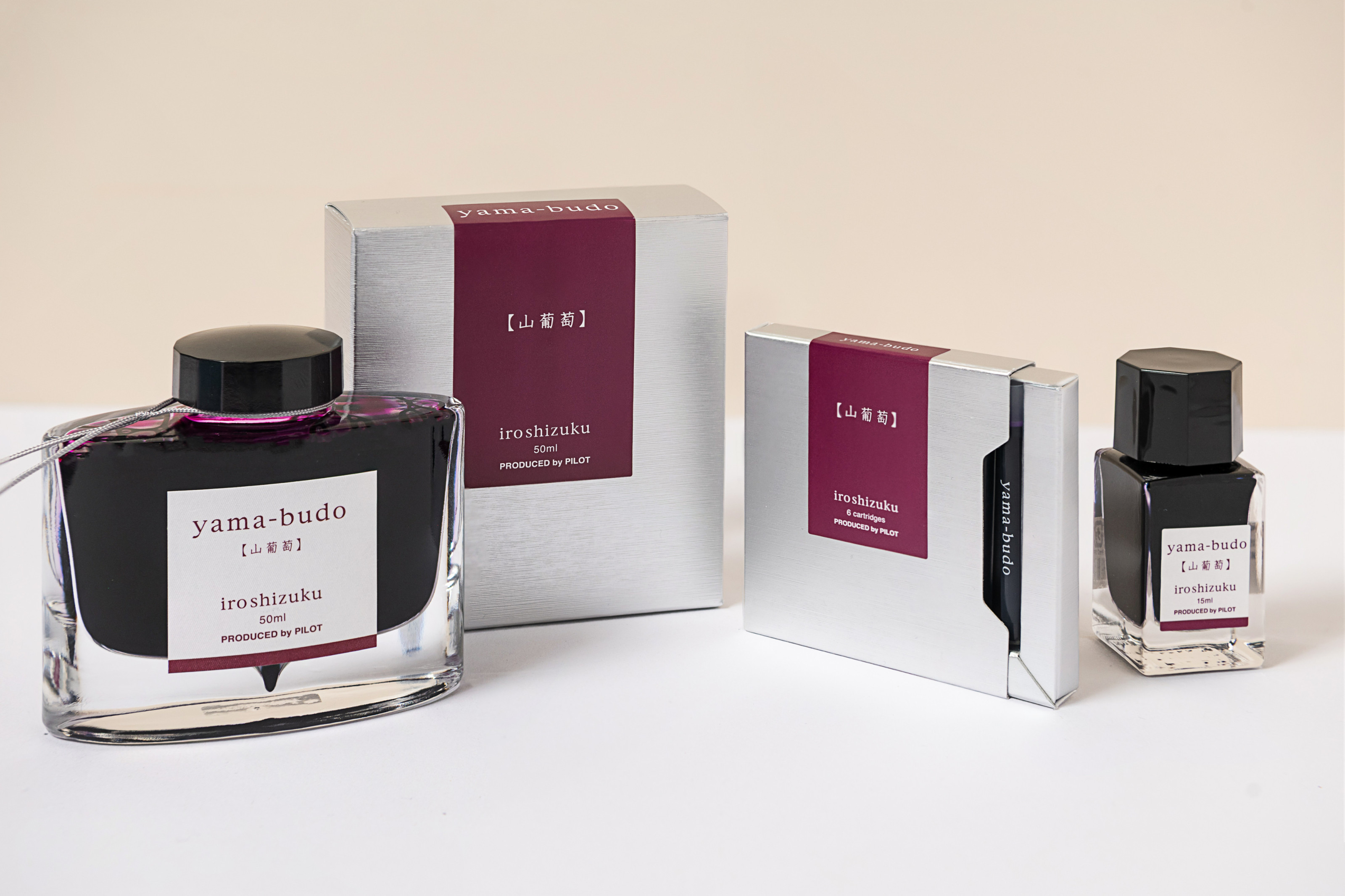 The iroshizuku Fountain Pen Ink Bottle in 50ml, 15ml and Ink Cartridges in the shade yama-budo, showcasing the elegant presentation and packaging of the ink. 