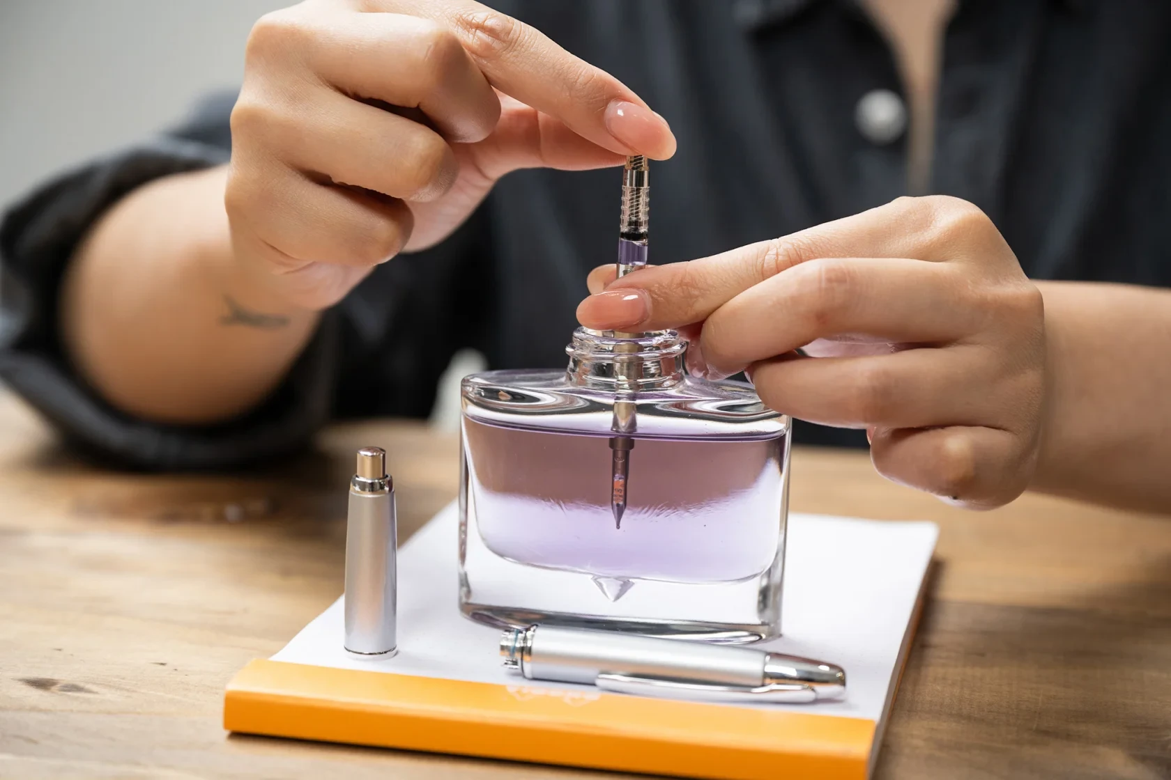 A woman carefully refilling PILOT Capless fountain pen with the Rotary Ink Converter: CON-40. 