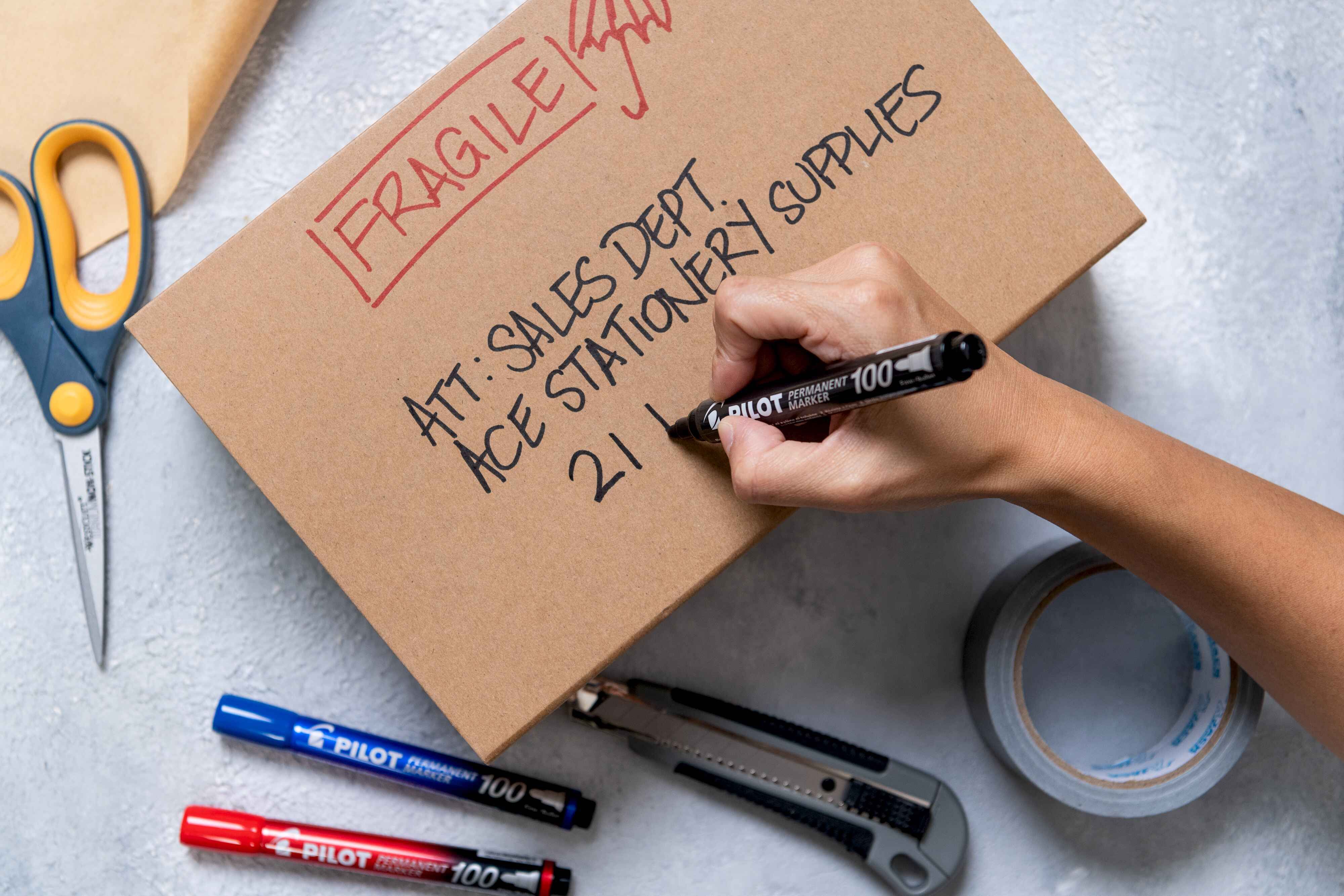 PILOT SCA-100 writing the postal address on a cardboard box, highlighting the importance of permanent markings for logistics.