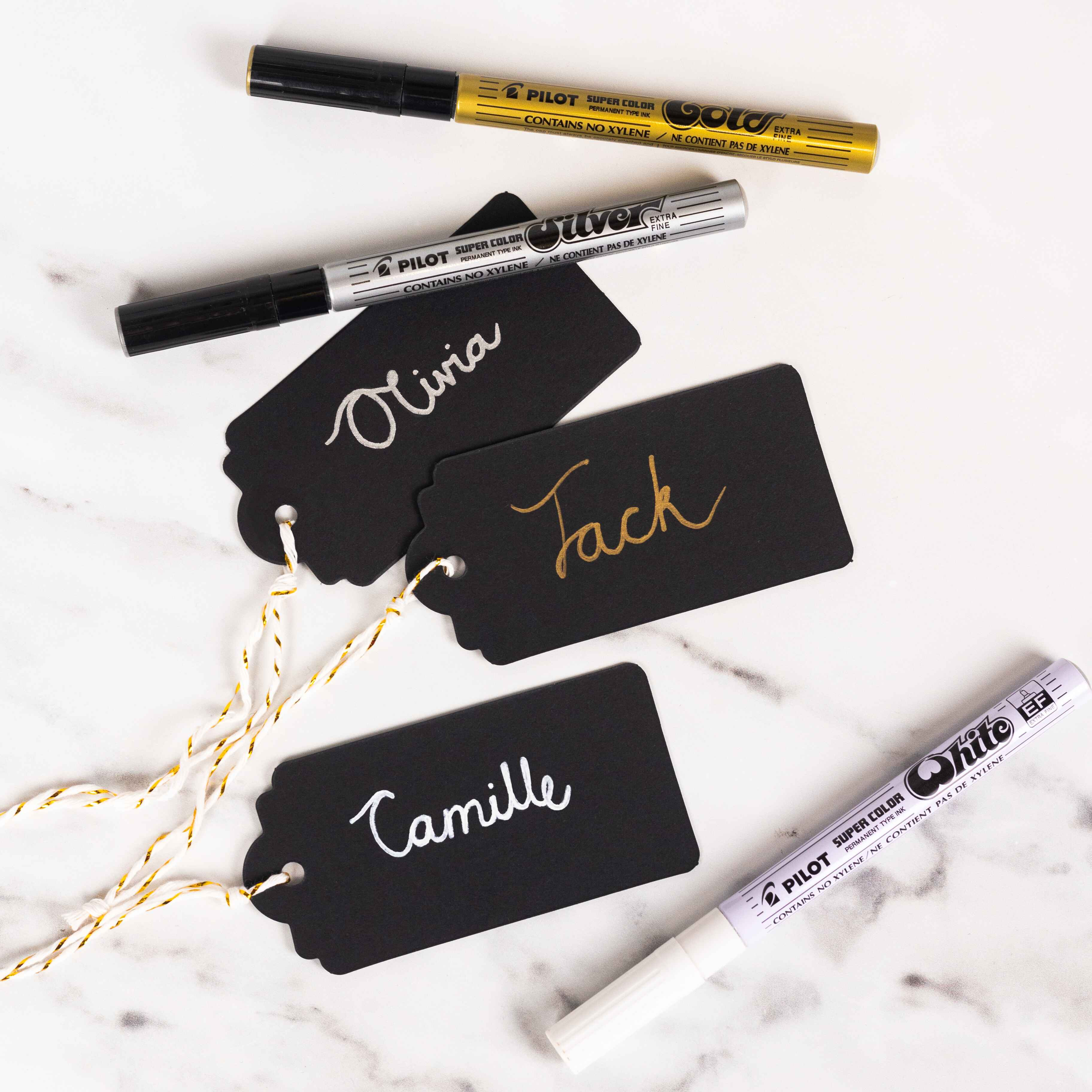 Black card name tags written with Super Color Markers in gold, silver and white.