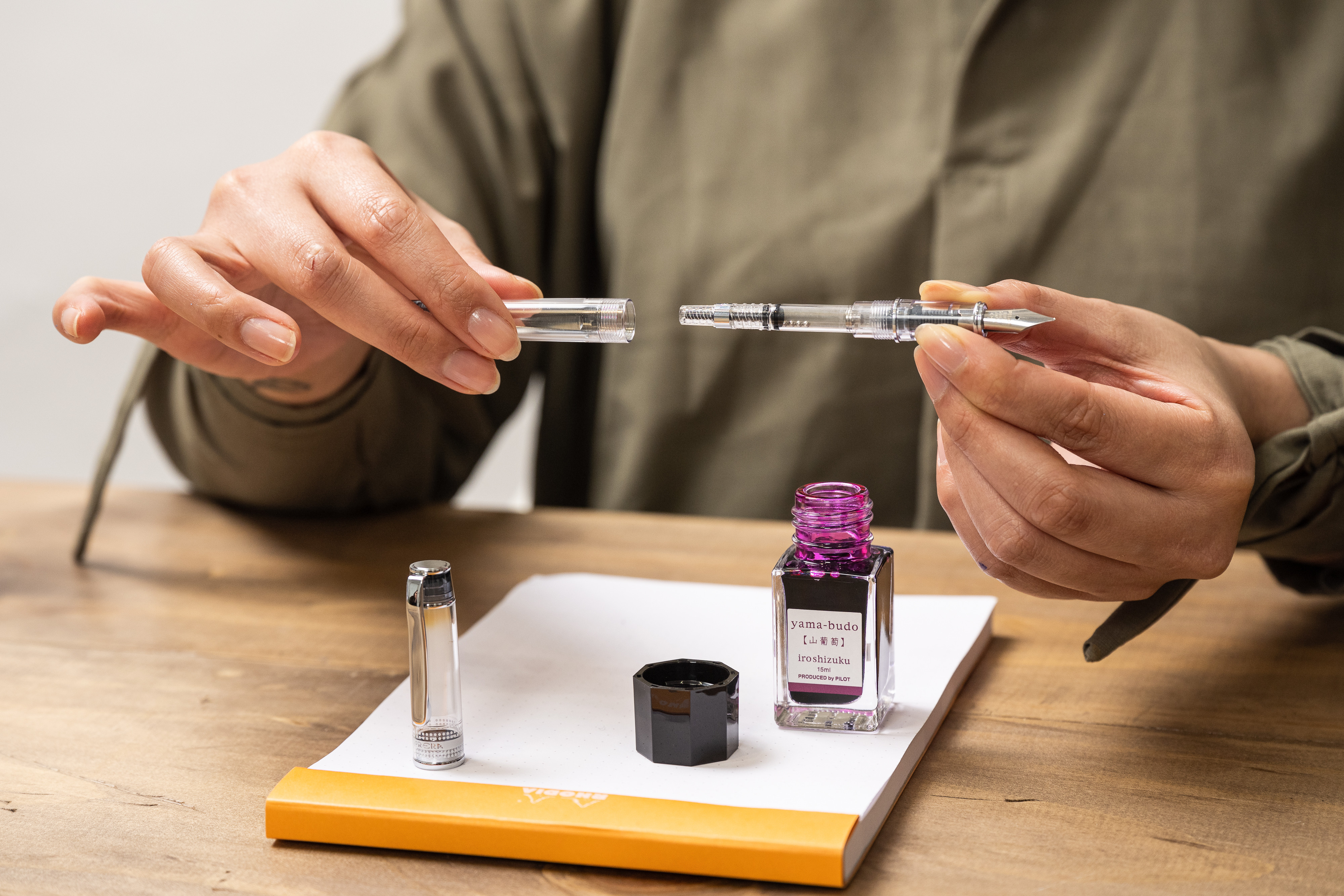 woman showing how to refill a PILOT luxury fountain pen with iroshizuku ink