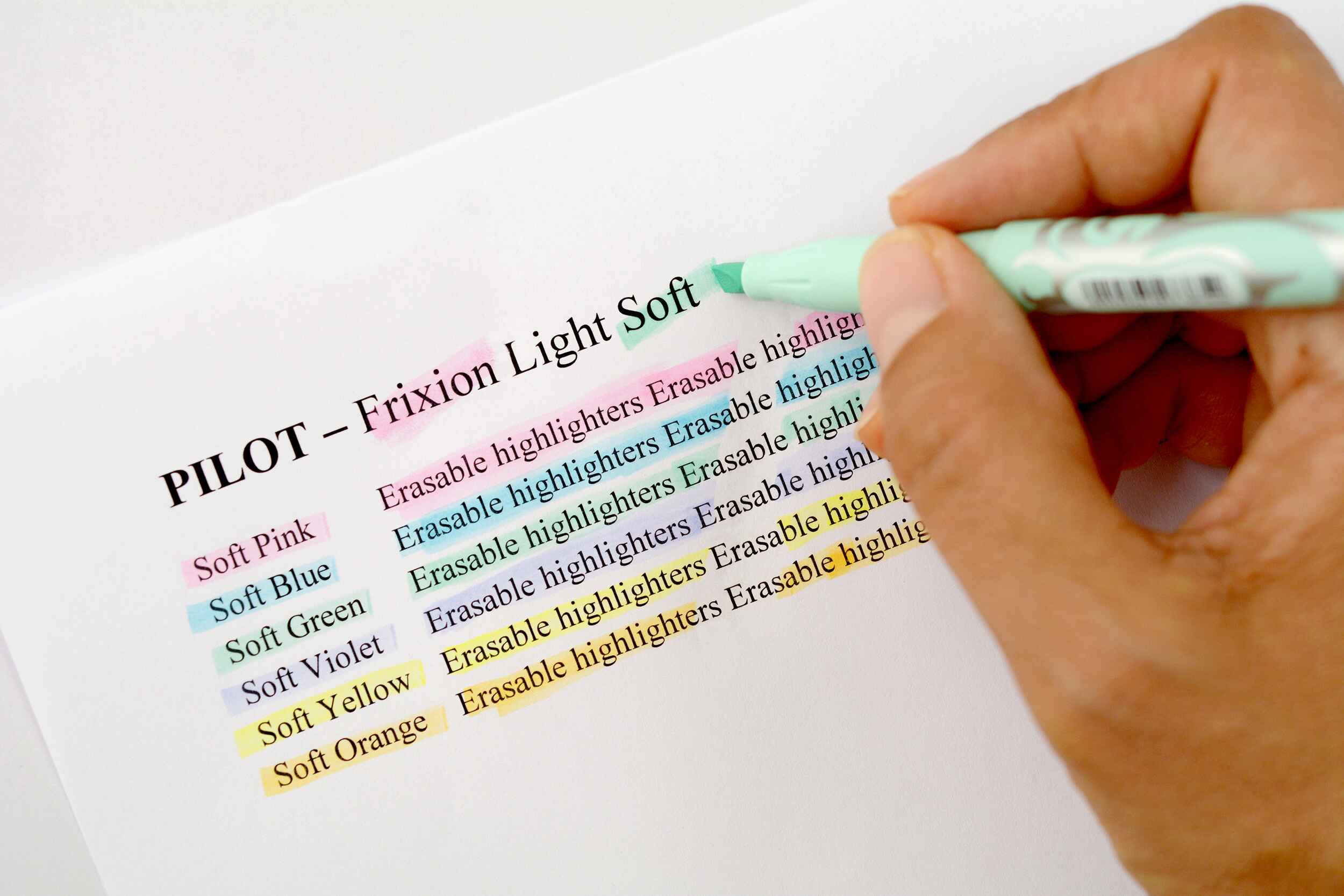 Close-up of a hand using a PILOT FriXion erasable highlighter in a soft green to mark text, showcasing the smooth and precise highlighting perfect for HSC study prep.