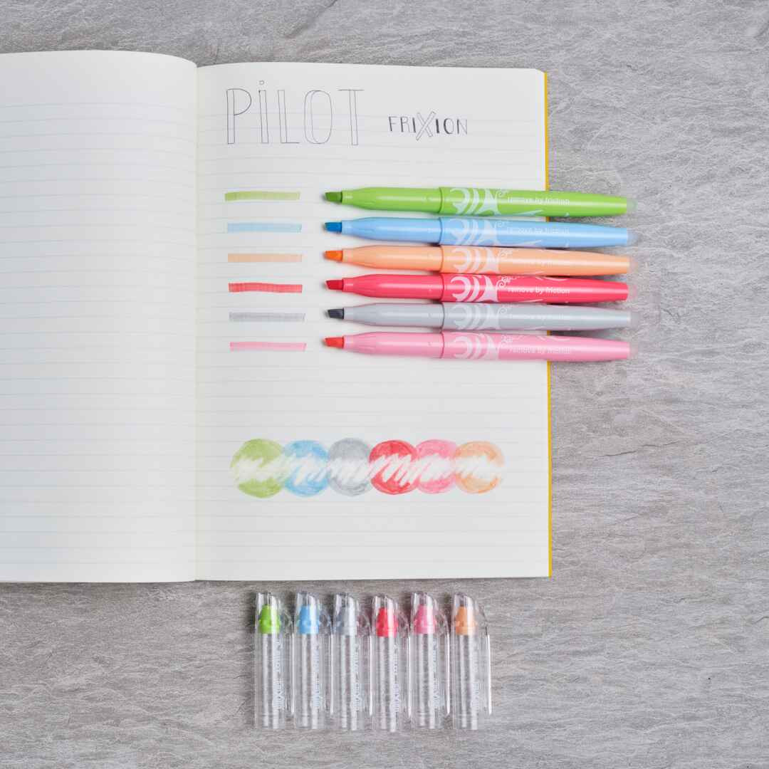 A swatch of PILOT FriXion erasable highlighters in different pastel colours in a copy book. 