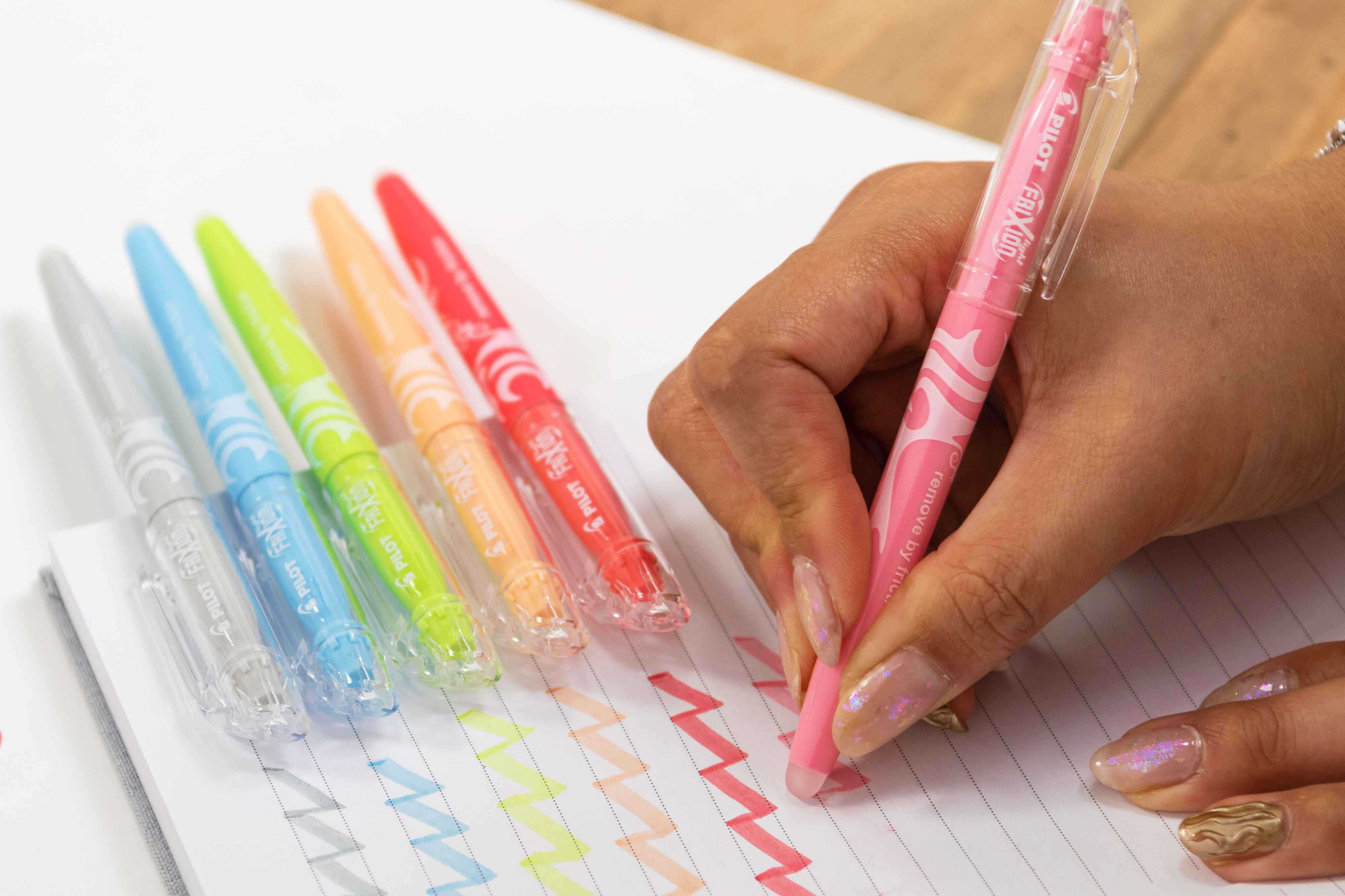 Swatch of PILOT FriXion erasable highlighters in pastel colours being erased with friction.