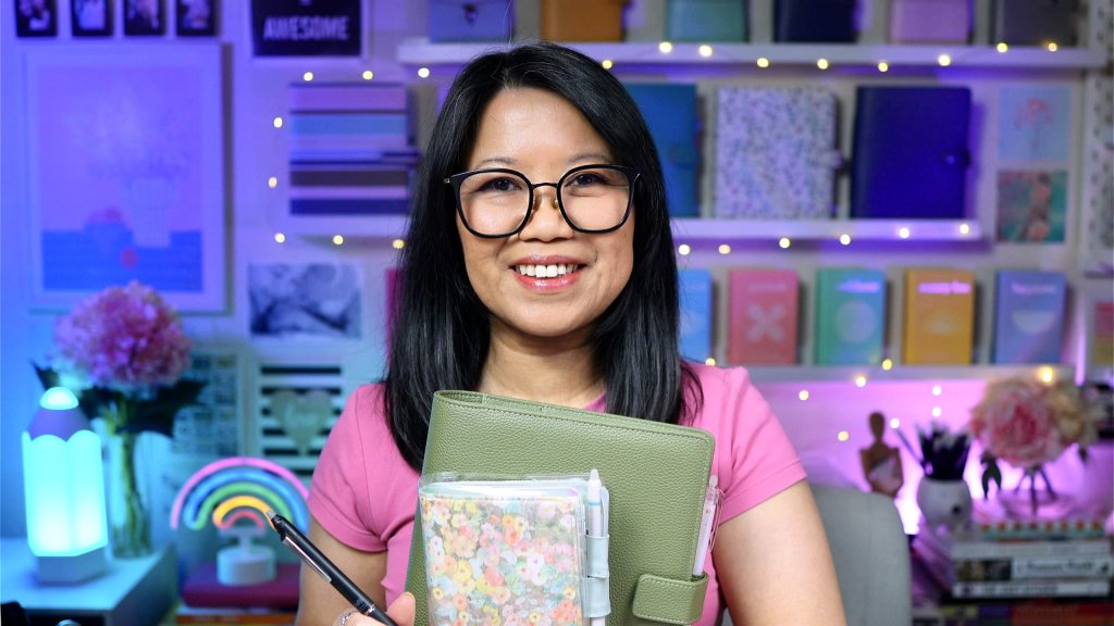 Mariane Cresp smiling while holding her planner and FriXion Zone erasable gel pen.