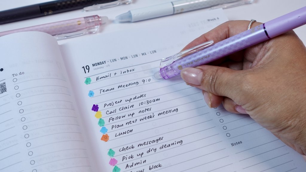 Close-up of planner pages with colour-coded notes being erased using a FriXion Clicker Limited Edition.