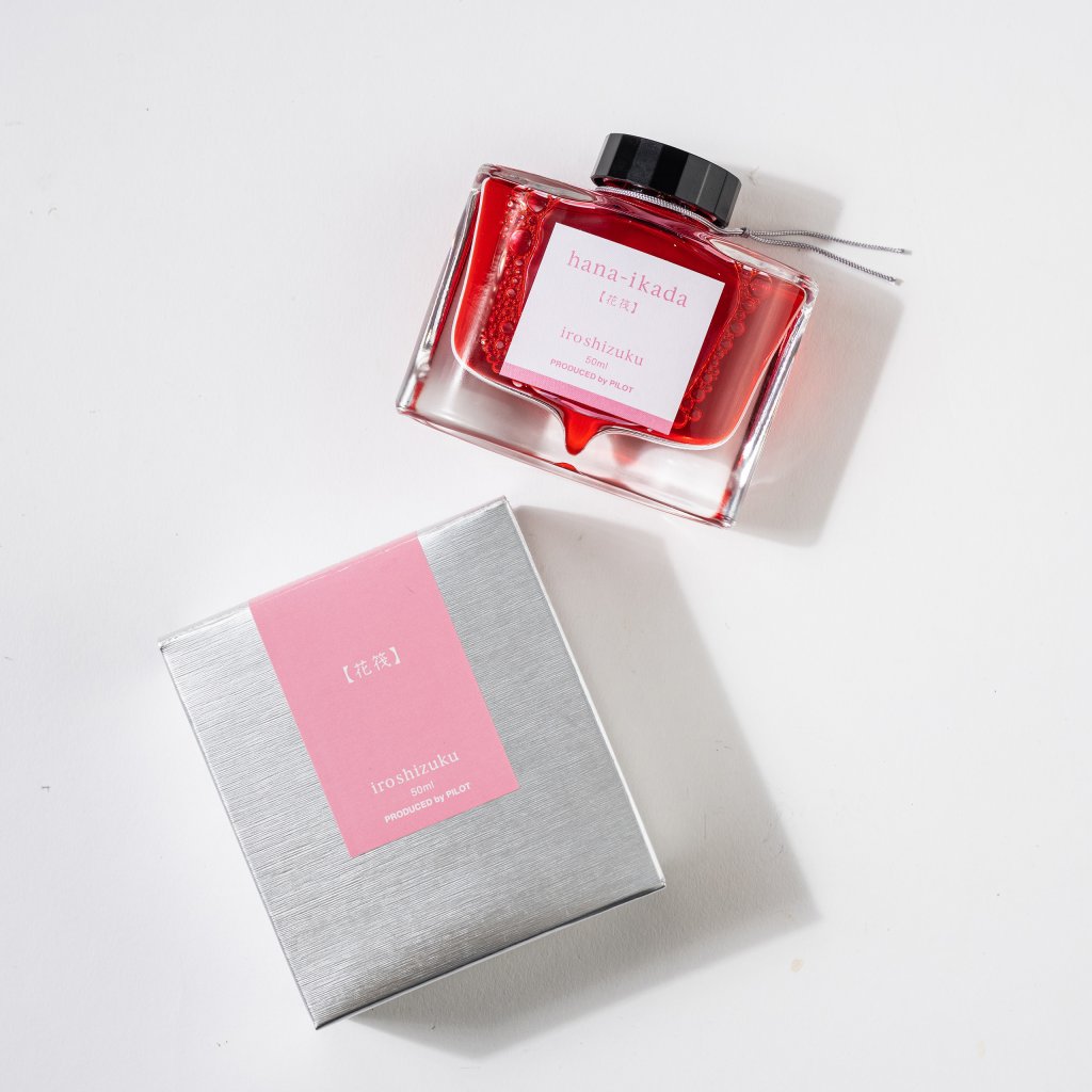 PILOT Pens iroshizuku Fountain Ink in red in a glass bottle with silver box on a white background.